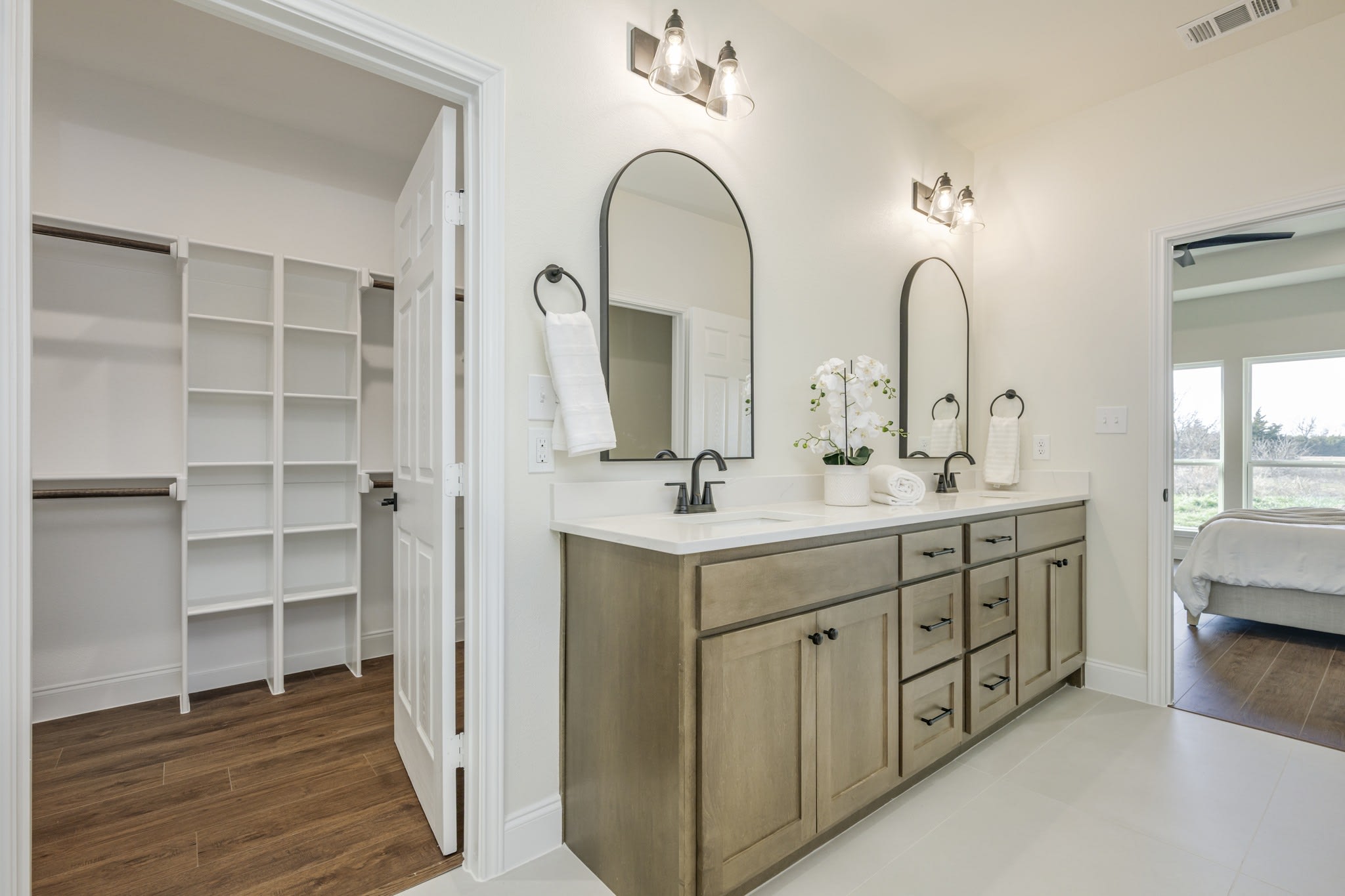 Primary bath renovation with double vanity and arched mirrors